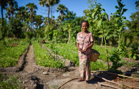 Natersia standing in front of her vegetable patch in Timor-Leste