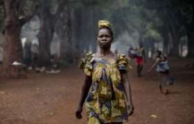 Marcelline walks to get water buckets from the OXFAM build bladder and pump in the Cesacoba site, 5kms away from Bangassou, on March 3rd, 2021.