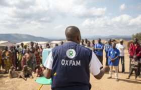 Oxfam Public Health Officer, demonstrating the new hand washing stand to the community in the displaced persons site of Mwaka.