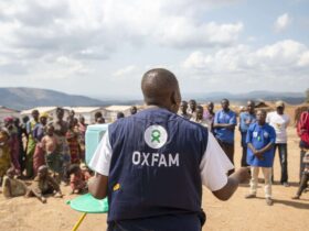 Oxfam Public Health Officer, demonstrating the new hand washing stand to the community in the displaced persons site of Mwaka.