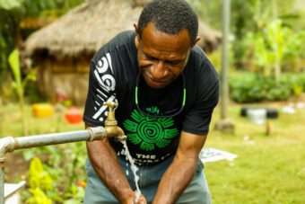 Andrew, an Oxfam in the Pacific staff member, washes his hands at one of the newly built taps in Nogorunte, Papua New Guinea