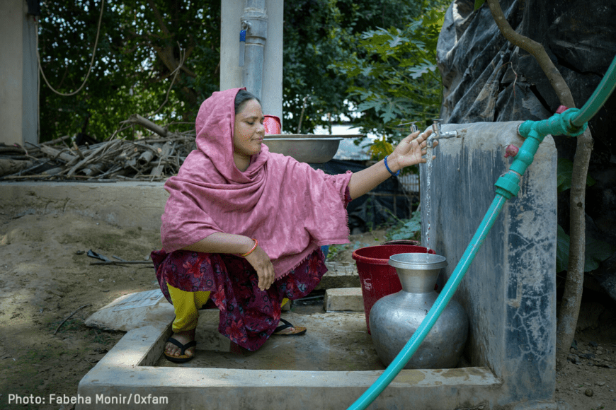 Woman using water point to pour water in jug