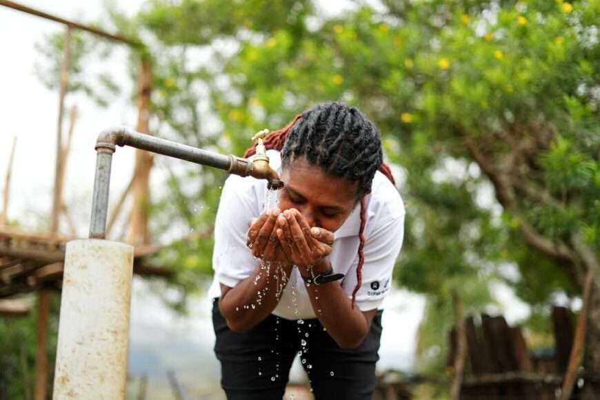 Woman in PNG using a newly installed tap that provides clean water