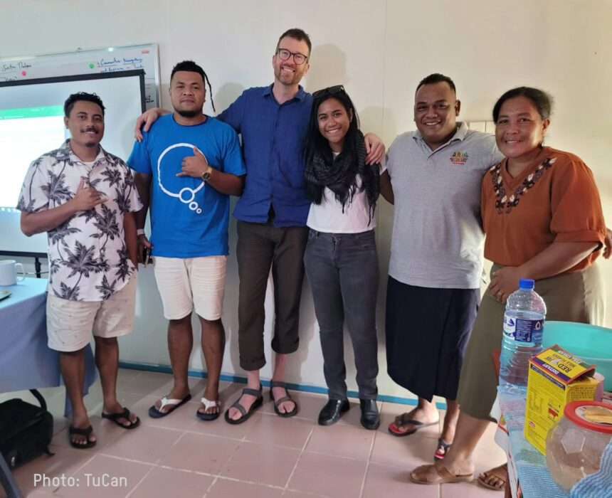 Group of people smiling at the camera after completing a workshop lead by TuCAN and Nick from Oxfam.