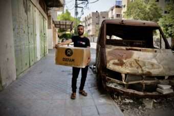 Man holding Oxfam food parcel in Gaza