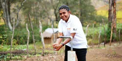 PNG Woman washing hands with new installed tap